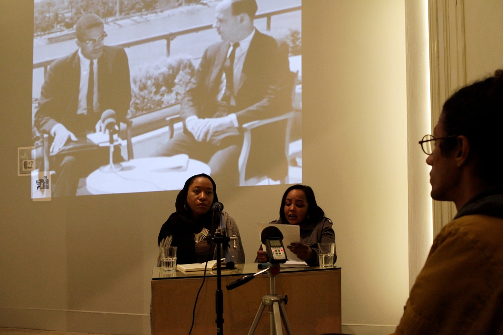 Nsenga Knight and Samah Gafar at the Contemporary Image Collective in Cairo presenting X Speaks in front of a full audience. A projection of Malcolm X interview in Cairo is behind them.